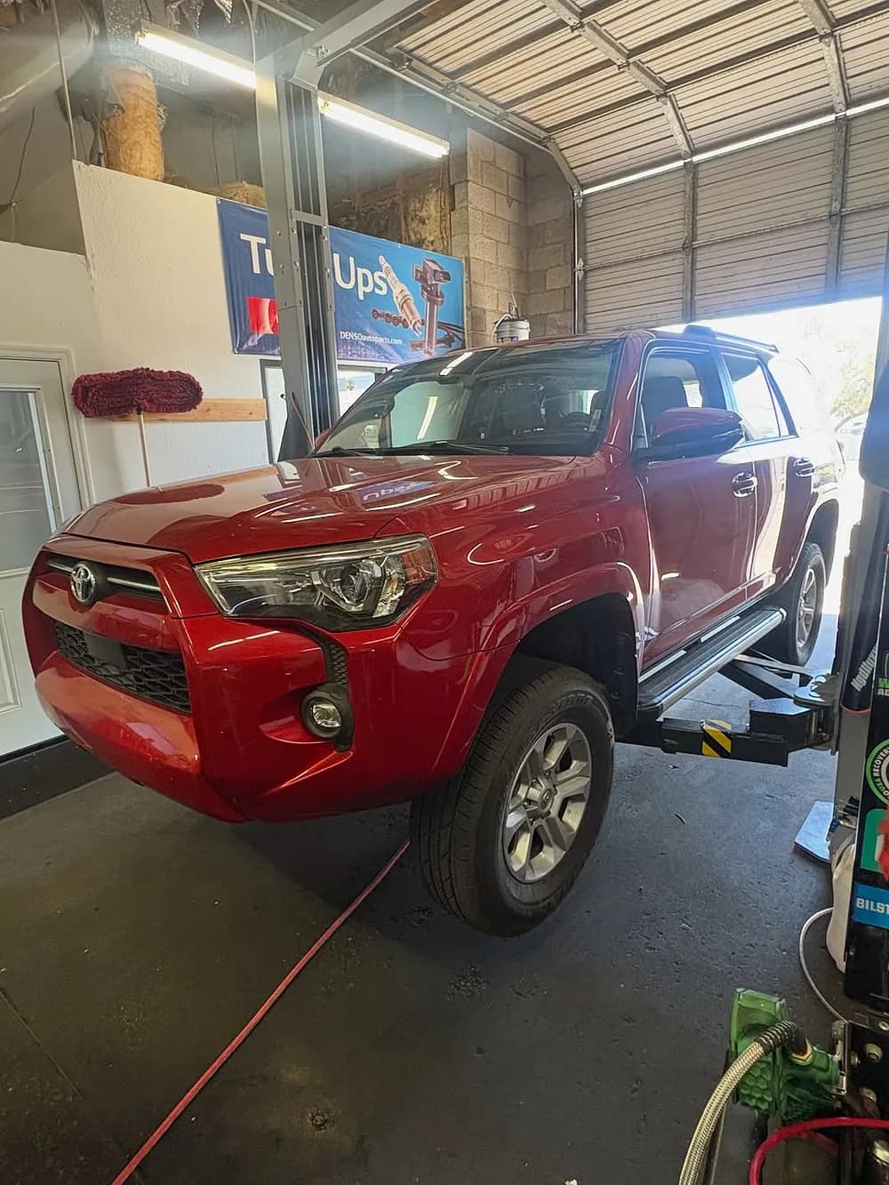 A vehicle up on the two-post lift for service at Mesa Auto & Fleet in Mesa, Arizona