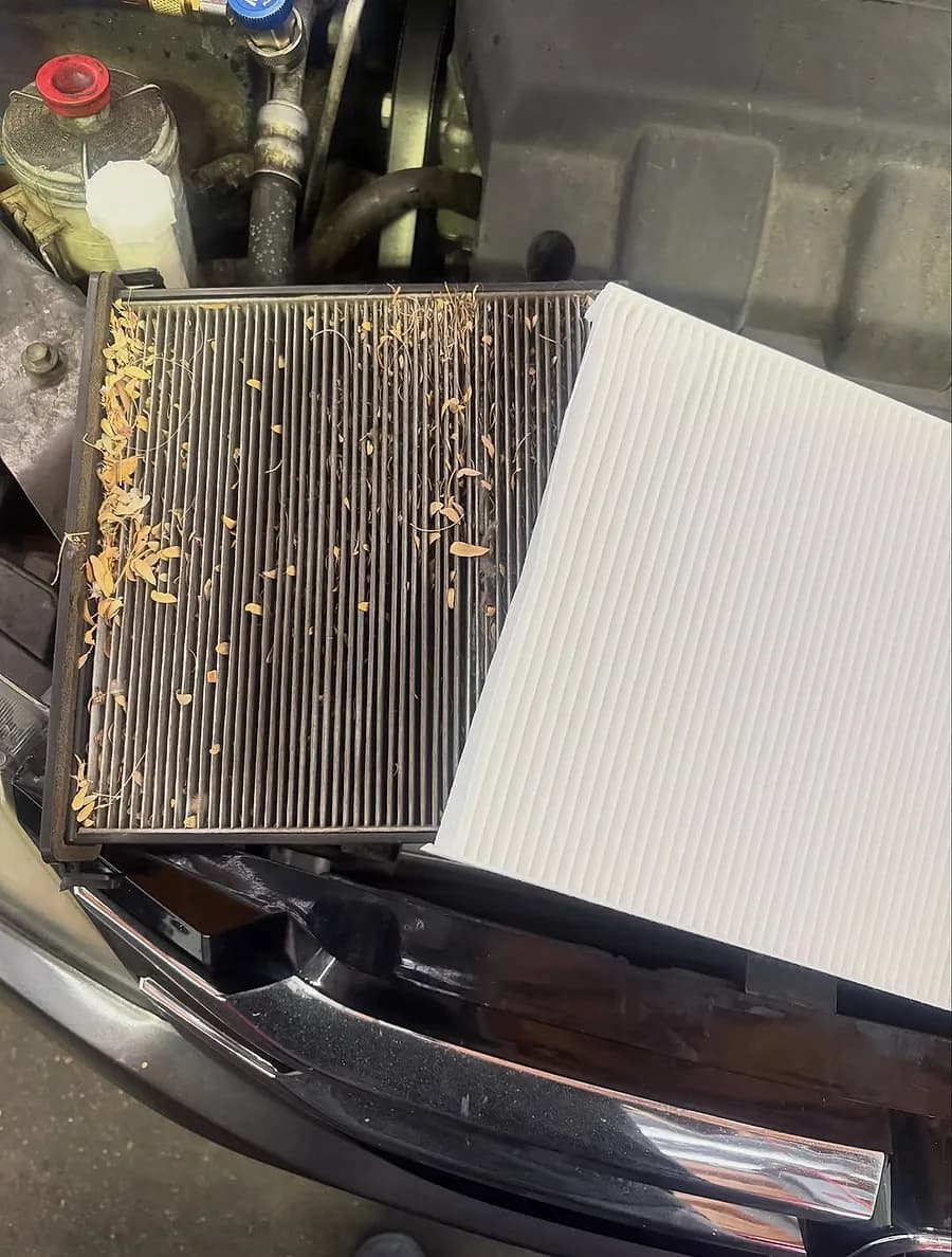 A used cabin air filter beside a clean replacement filter