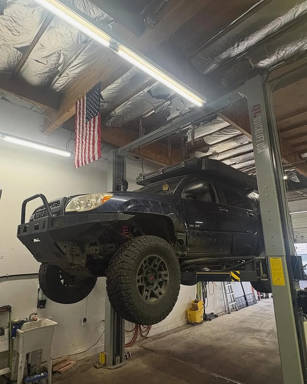 A lifted Toyota 4Runner up on the two-post lift at Mesa Auto & Fleet in Mesa, Arizona