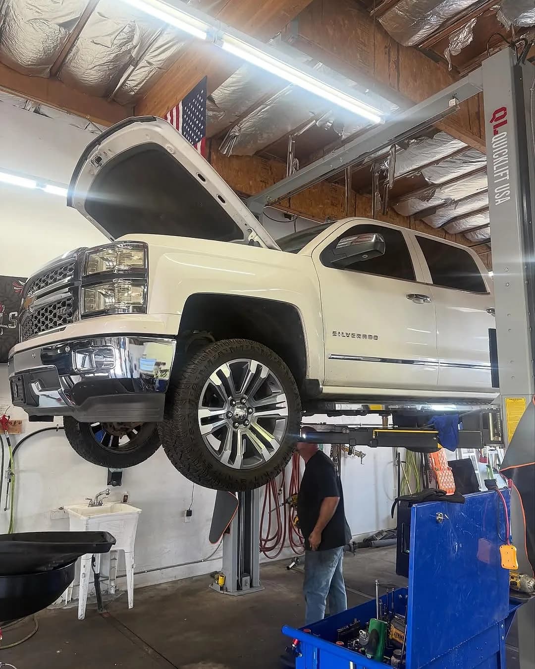 A Chevrolet Silverado on a lift inside Mesa Auto & Fleet's shop