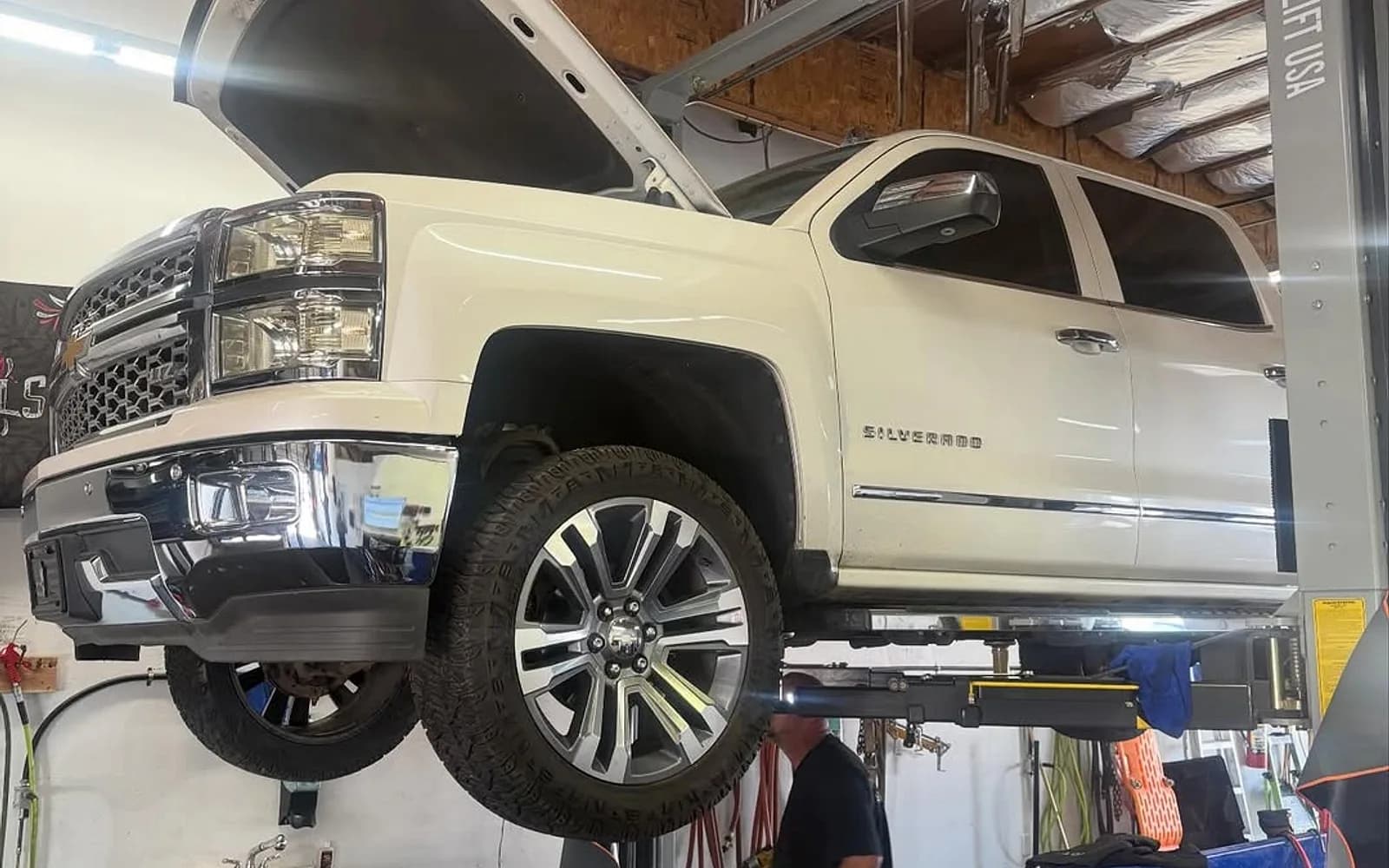 A Chevy Silverado work truck up on the lift for service at Mesa Auto & Fleet in Mesa, Arizona