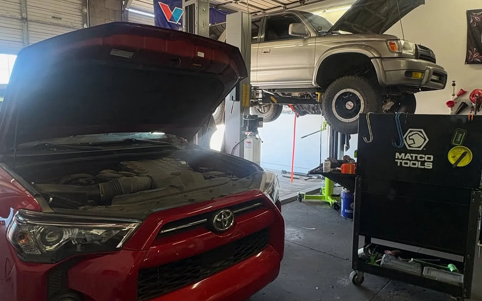A busy service bay at Mesa Auto & Fleet with vehicles being worked on out in the open